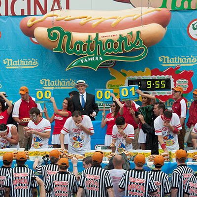 This is a photo of contestants eating hot dogs at Nathan's Hot Dog Eating Contest.
